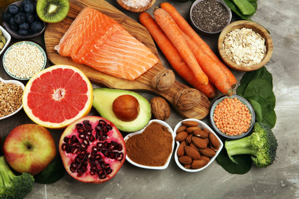 istock Healthy food clean eating selection: fish, fruit, vegetable, cereal, leaf vegetable on rustic background 1209946217