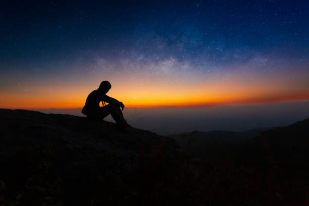 silhouette des jungen mannes sitzt auf dem gipfel bergblick allein bei sonnenaufgang blick auf den himmel blick auf die sterne und die milchstraße in der einsamen nacht, kopie raum, bolivien, südamerika, stern - raum, astronomie, star - milky way galaxy star space stock-fotos und bilder