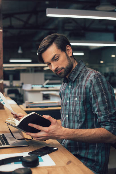 istock Calm attractive man opening his notebook stock photo 1209949256
