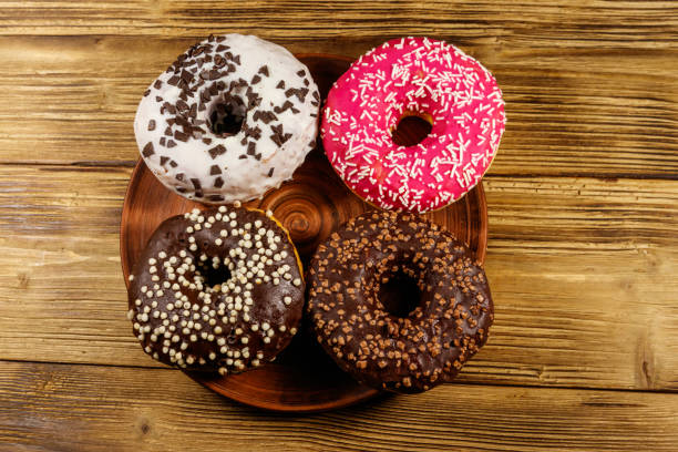 istock Tasty donuts on a wooden table. Top view 1209950845
