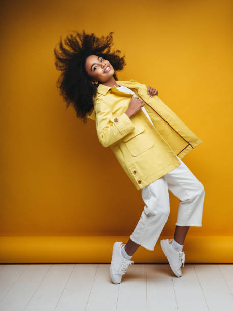 mujer joven con impermeable - amarillo color fotos fotografías e imágenes de stock