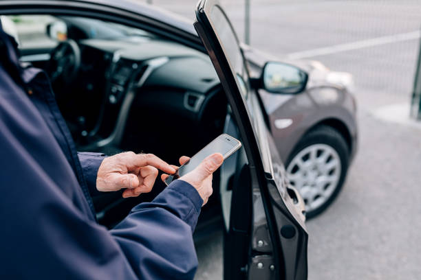 Male hands typing on cell phone. Unrecognizable mature man standing at rental car with smartphone. Male hands typing on cell phone. Unrecognizable mature man standing at rental car with smartphone. carsharing photos stock pictures, royalty-free photos & images