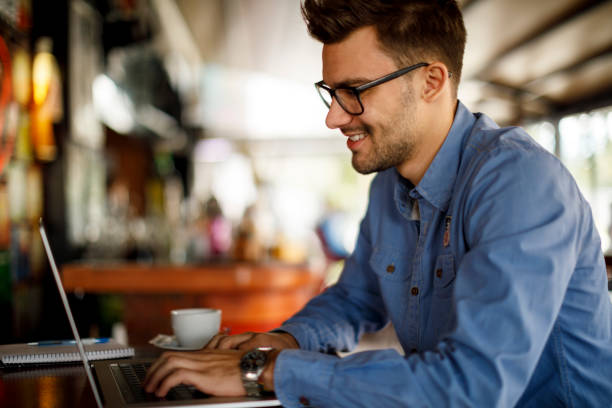istock Young man sitting in coffee shop and using laptop 1209952869