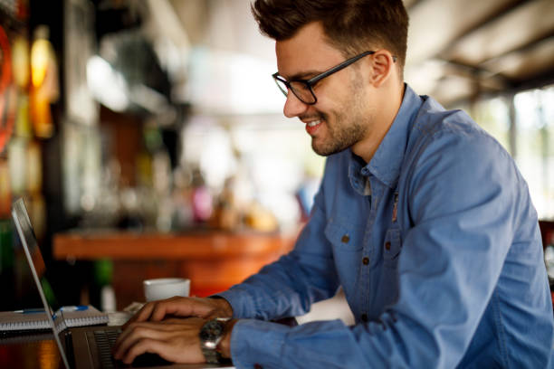 istock Young man sitting in coffee shop and using laptop 1209952902
