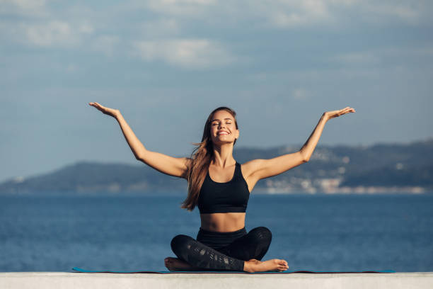 istock Young woman meditating outdoors 1209954414