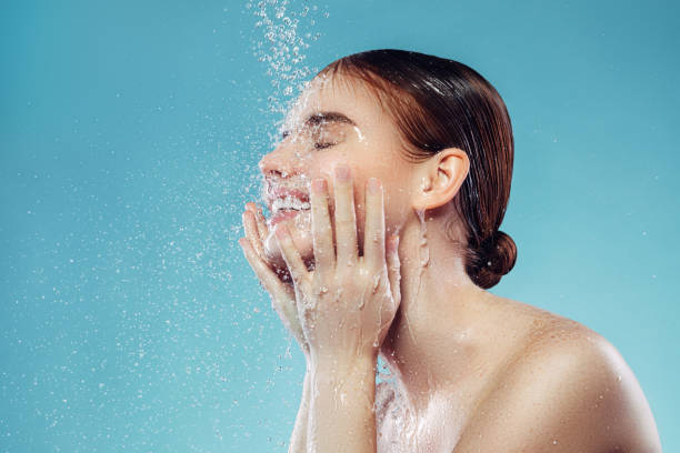 女の子は彼女の顔をすすくう - human face water washing women ストックフォトと画像