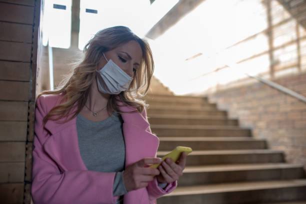 istock Young woman with protective mask is using phone. 1209958267