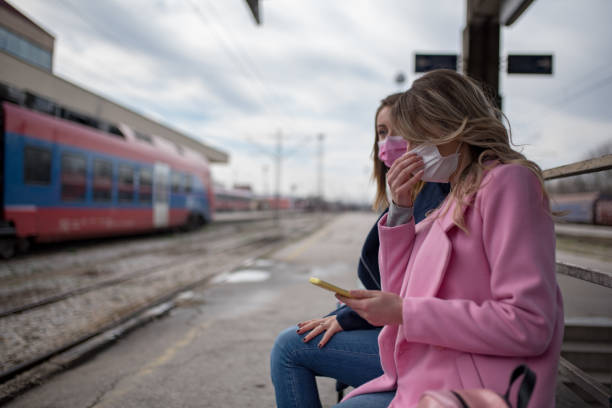 istock Two girls with protective masks waiting for train 1209958496