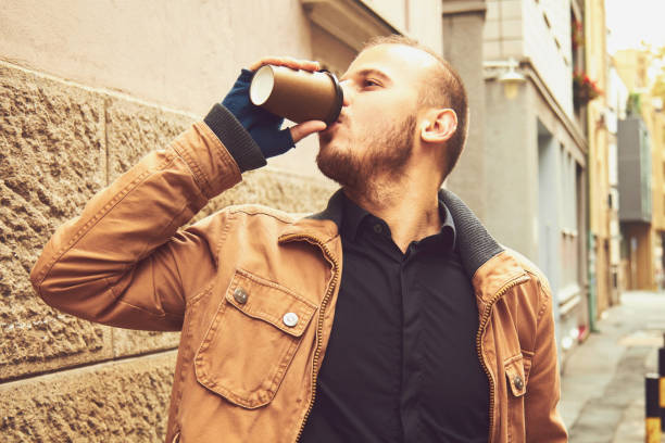 istock Handsome man drinking hot coffee on the street. 1209959509