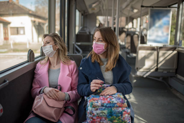 Two women at public transport during virus epidemic stock photo