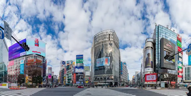 A panorama picture of the Shibuya Crossing, taken from the street level, in Tokyo.