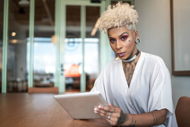 portret wytatuowanego bizneswoman za pomocą cyfrowego tabletu w pracy - alternative culture zdjęcia i obrazy z banku zdjęć