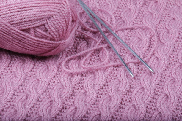 istock Pink woolen threads for knitting and knitting needles. 1209966656