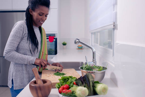 istock Woman preparing fresh salad on the kitchen countertop. 1209968519