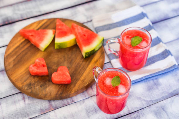 istock Watermelon pieces and juice in glass cups on table 1209968523