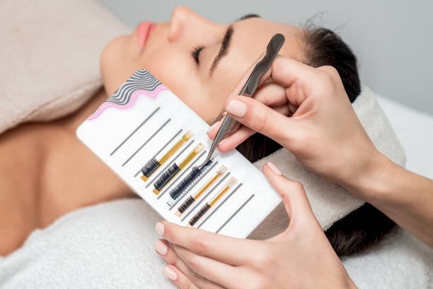 istock Beautician taking eyelashes by tweezers. 1209968875