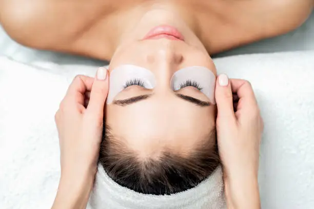 Photo of Hands glues ribbon under eyes.