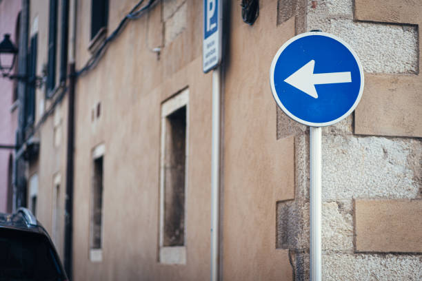istock White arrow blue traffic signal on a street corner pointing left 1209969618