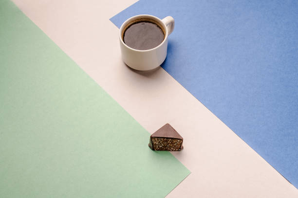 istock A Cup of coffee in a white mug with dark chocolate on a colored background 1209970198