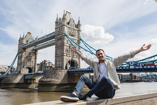 Man posing for a picture near the big Thames river bridge