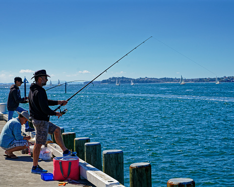 Devonport, Auckland/New Zealand - March 3, 2019: People fishing off the pier at Devonport, Auckland, New Zealand.