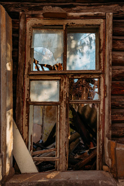 istock Broken window of old abandoned wooden building 1209982913