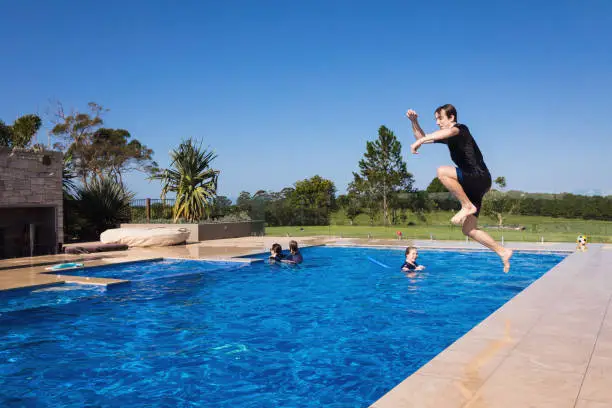 Photo of Teenage Boy Cannonballing Into Swimming Pool