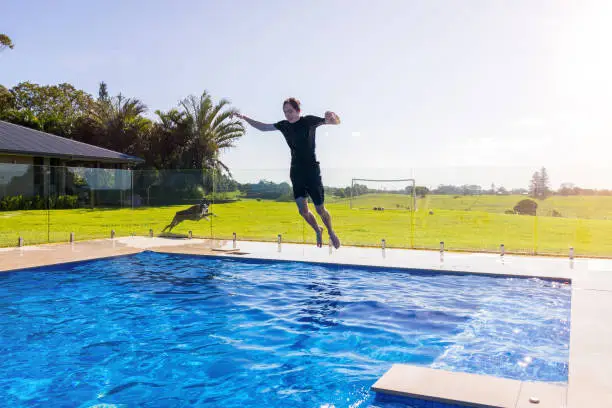 Photo of Teenage Boy Cannonballing Into Swimming Pool