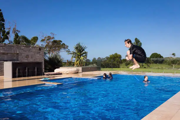 Photo of Teenage Boy Cannonballing Into Swimming Pool