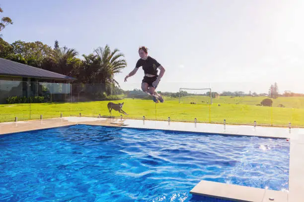 Photo of Teenage Boy Cannonballing Into Swimming Pool