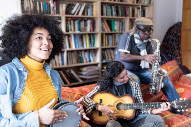 istock Musicians playing the guitar, drum and saxophone in home studio 1209985093