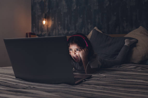 istock little girl lying in bed screaming to a computer 1209985760