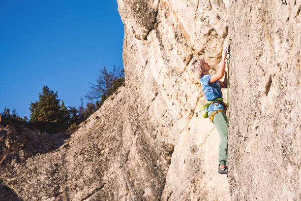 istock Woman climbs a rock. 1209985821