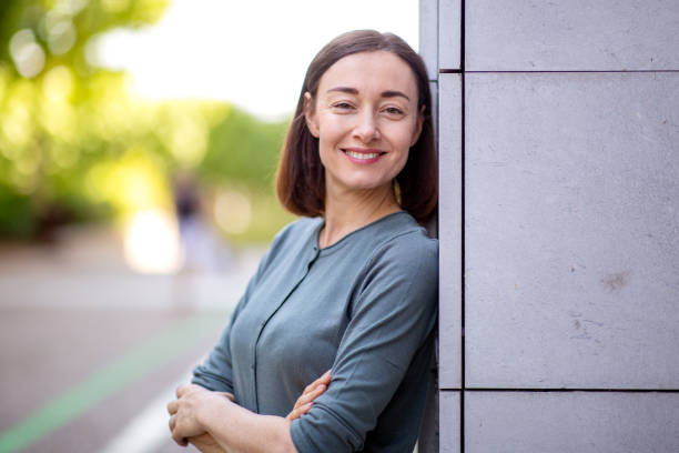 istock older woman smiling outdoors 1209986323