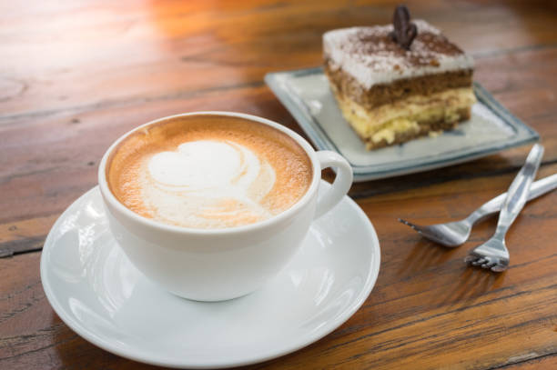 istock Hot coffee cup on plate with tiramisu cake. 1209986380