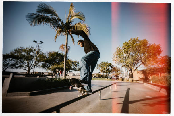 A skateboarder in LA, California rides at a skatepark, attempting an assortment of flip tricks and grinds.  Youth culture and skill in extreme sports.