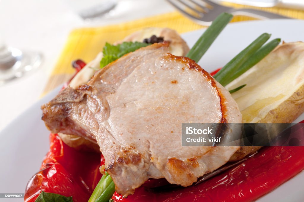 Chuletas de cerdo asado con papas y pimientos rojos - Foto de stock de Alimento libre de derechos