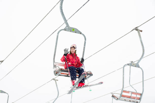 Ski resort Woman waving hand from ski lift japanese snowboarder stock pictures, royalty-free photos & images