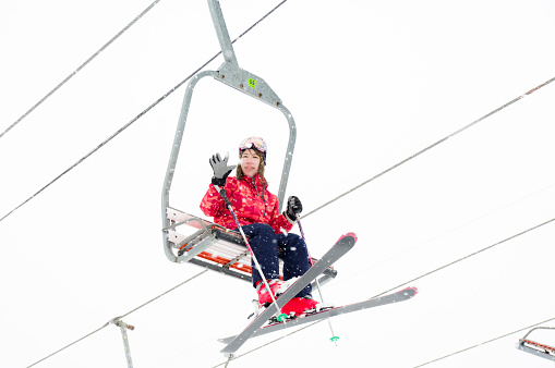 Woman waving hand from ski lift