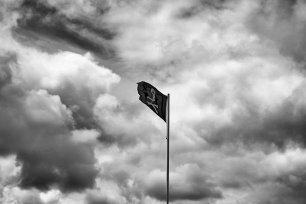 Mast of a ship displaying the pirate flag on a flagpole in The Hague, ZH, Netherlands