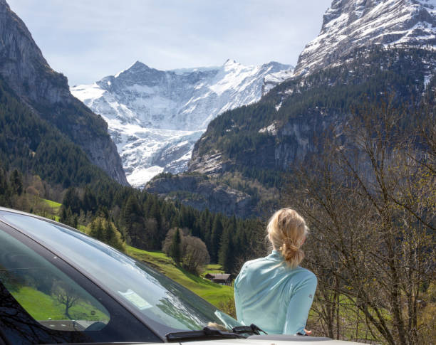 woman relaxes by car door, in mountains - on top of mountain peak success cold imagens e fotografias de stock