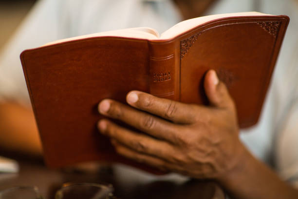 istock African American man praying and reading the Bible. 1209997333