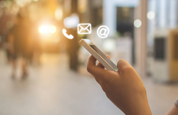 istock Close up image hand using smartphone with icon telephone email mobile phone and address. Contact us connection and e-mail marketing concept 1209998416