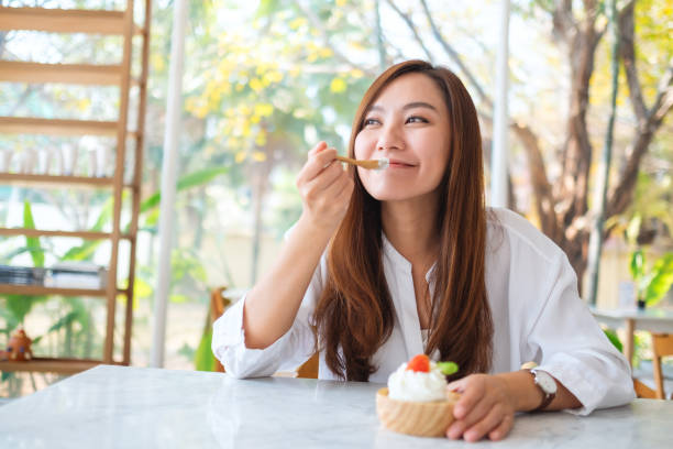 una hermosa mujer asiática disfrutar comiendo un helado en el restaurante - gourmet enjoyment food freshness fotografías e imágenes de stock