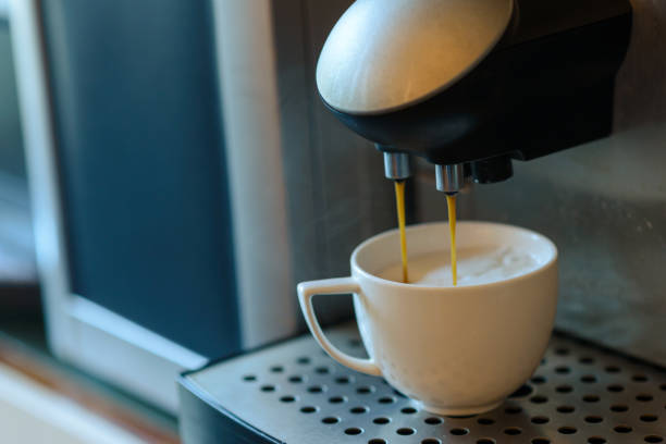 istock White cup standing on grating of automatic coffee maker machine. Coffee pouring in the cup. Coffee break concept 1209999440