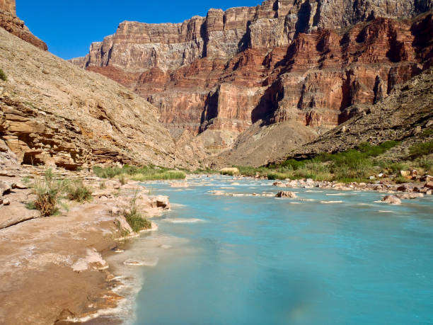 The Little Colorado River runs turquoise blue due to alkalai minerals dissolved int its waters on a sunny spriong day.