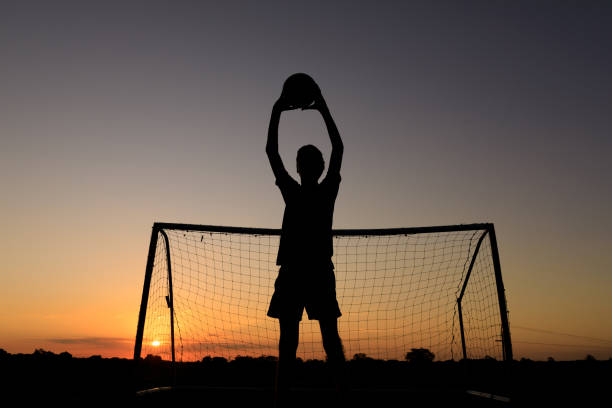 istock Boy Practicing Soccer Skills At Sunset 1210009141