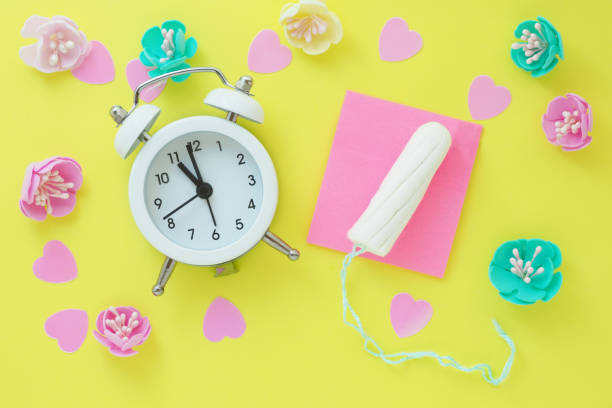 istock a small white alarm clock, a tampon, pink hearts and artificial multi-colored flowers. the concept of menstruation, ovulation, contraception. 1210012126