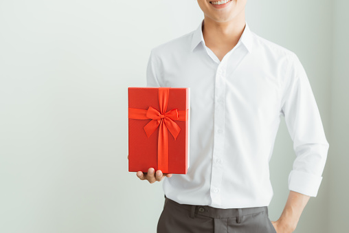 Young businessman holding with red gift box