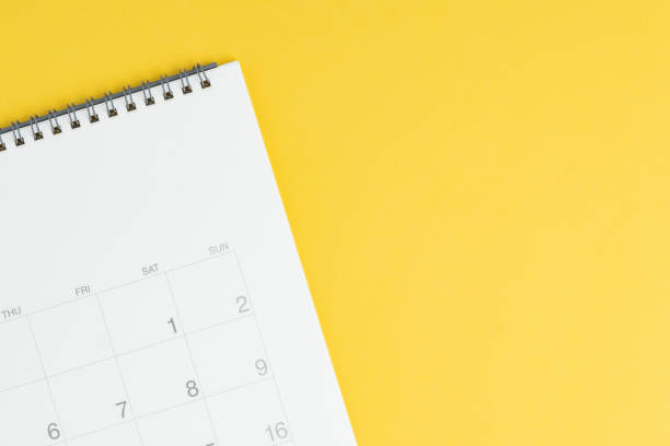 istock Calendar with blank copy space to put month and year on solid yellow background, flat lay or top view with calendar on the left and text space on the right 1210023601